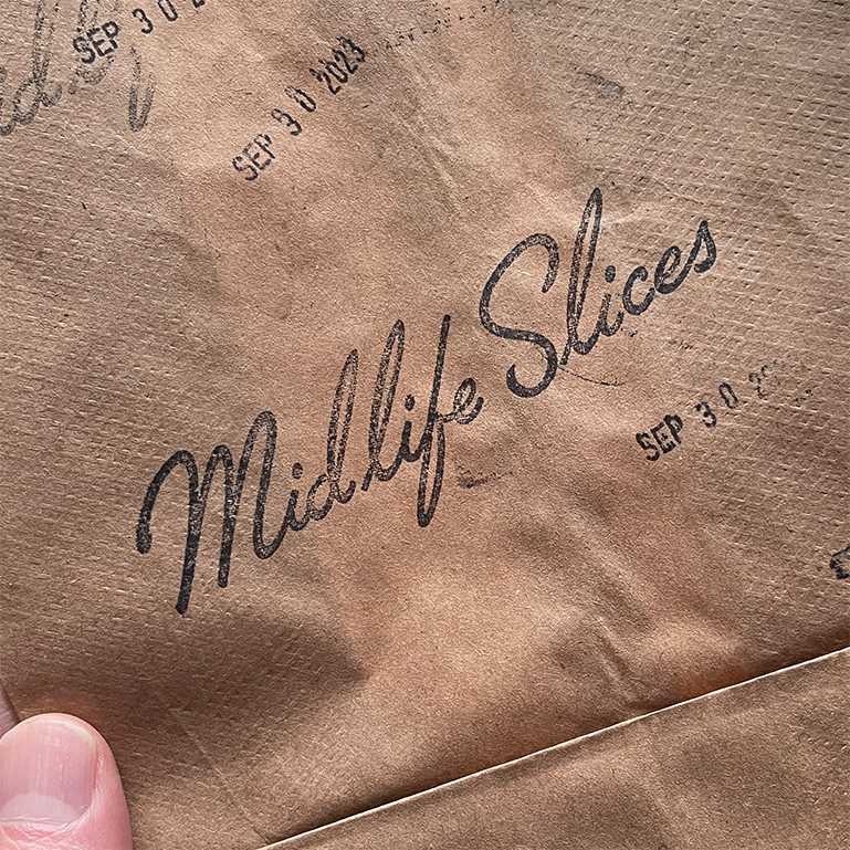 Midlife Slices logo stamped on a brown bag