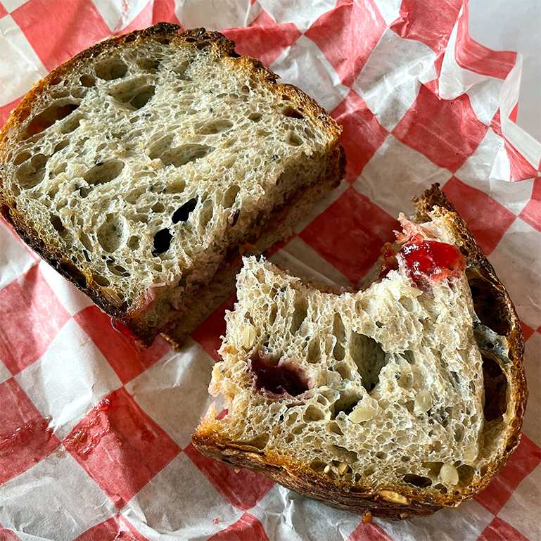 PB&J sandwich on sourdough bread, sliced in half