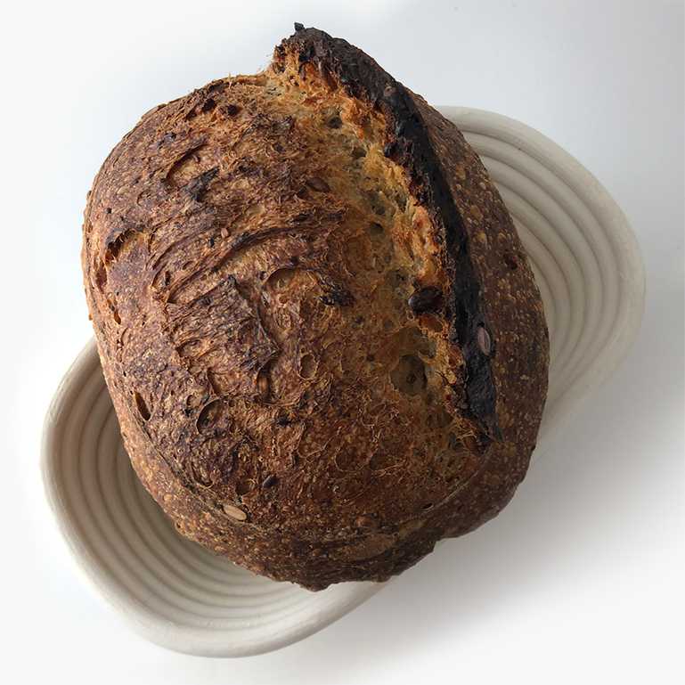 Baked sourdough bread resting in banneton